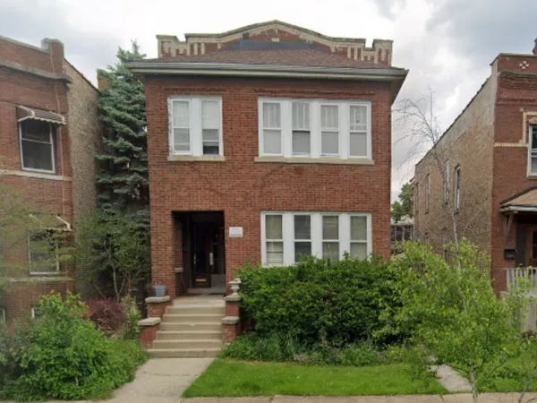 a front view of a house with plants and garden