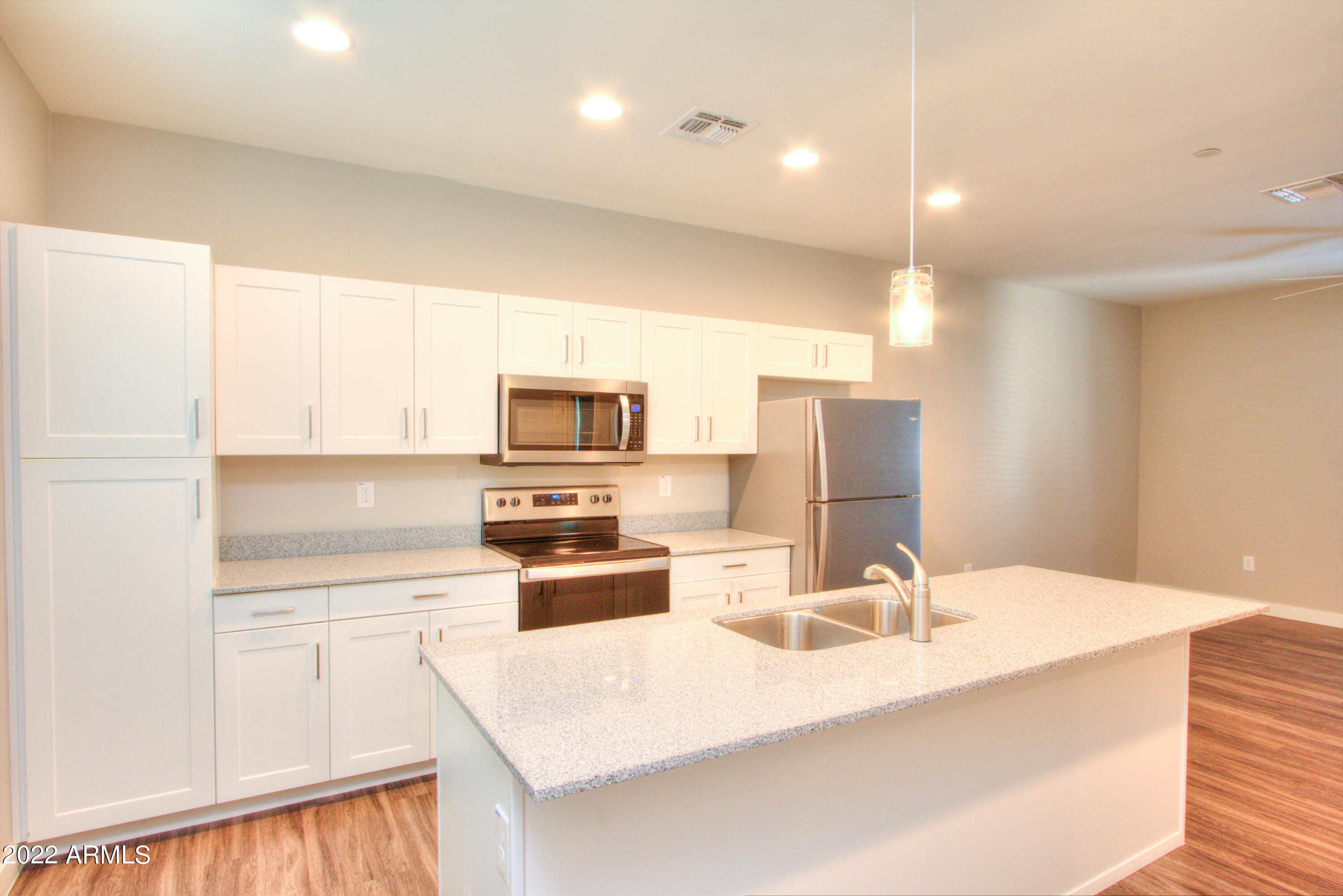 2245 North Dayton Street, Unit 3 Phoenix, AZ 85006 - Photo 5 of 26 a kitchen with stainless steel appliances a sink a stove a microwave a refrigerator a white counter and cabinets