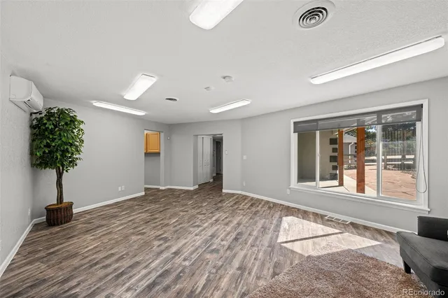 a view of an empty room and window with wooden floor