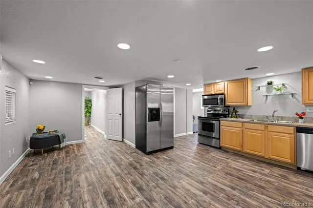 a kitchen with stainless steel appliances granite countertop a refrigerator and a stove top oven