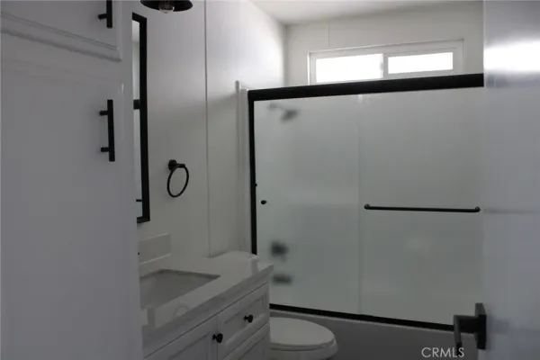a bathroom with a granite countertop sink mirror and toilet
