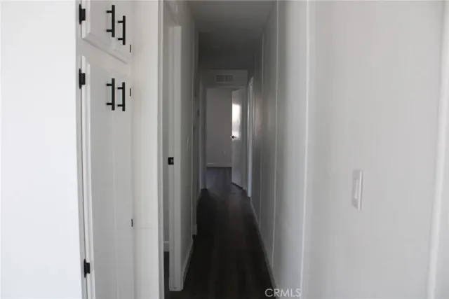 a view of a hallway with wooden floor and closet