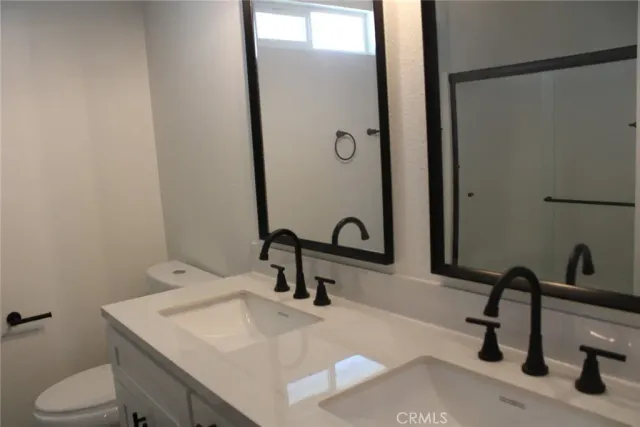 a bathroom with a sink a toilet and a mirror