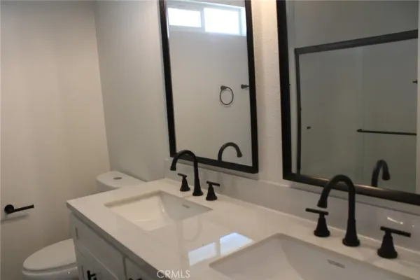 a bathroom with a sink a toilet and a mirror