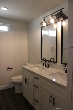 a bathroom with a granite countertop sink toilet and a mirror