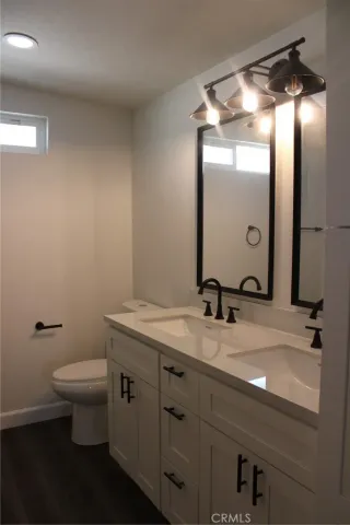 a bathroom with a granite countertop sink a toilet and a mirror