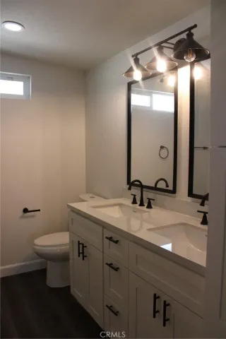 a bathroom with a granite countertop sink a toilet and a mirror