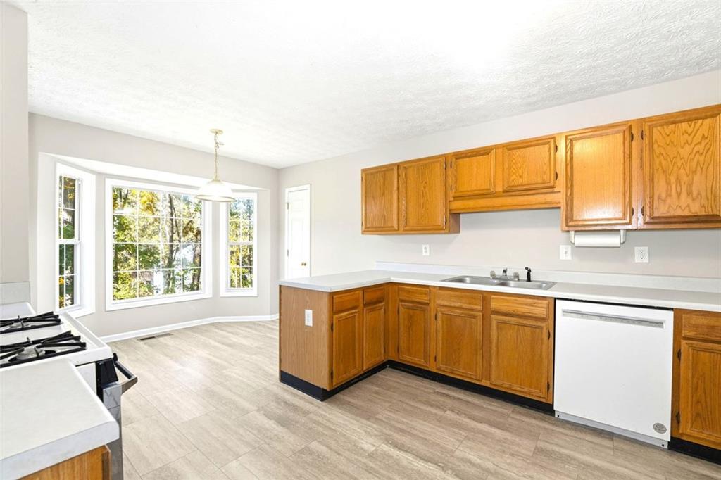 4099 Harvest Ridge Drive Douglasville, GA 30135 - Photo 15 of 46 a large kitchen with granite countertop a sink and a stove top oven