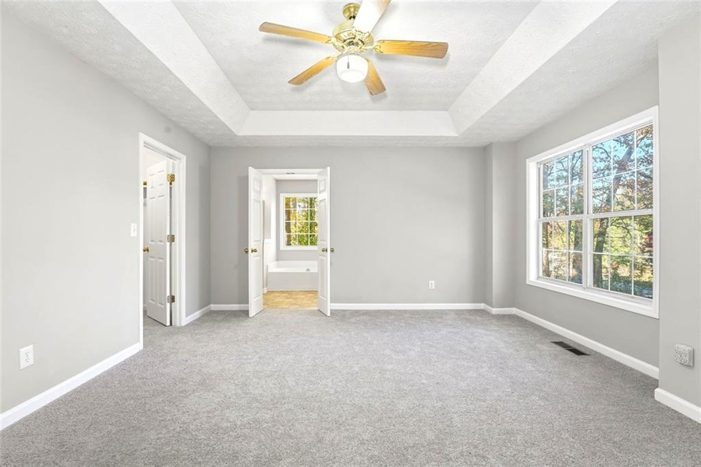 4099 Harvest Ridge Drive Douglasville, GA 30135 - Photo 20 of 46 an empty room with chandelier fan and windows
