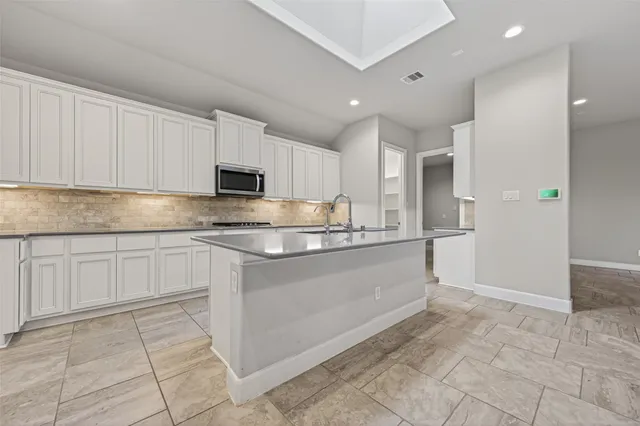 a kitchen with granite countertop a stove a sink and a microwave