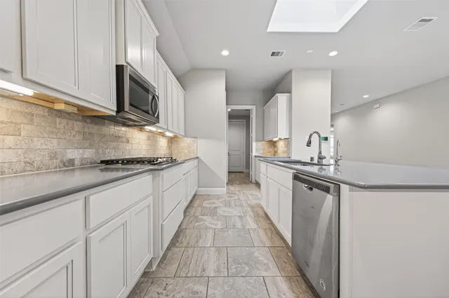 a large kitchen with stainless steel appliances lots of counter top space