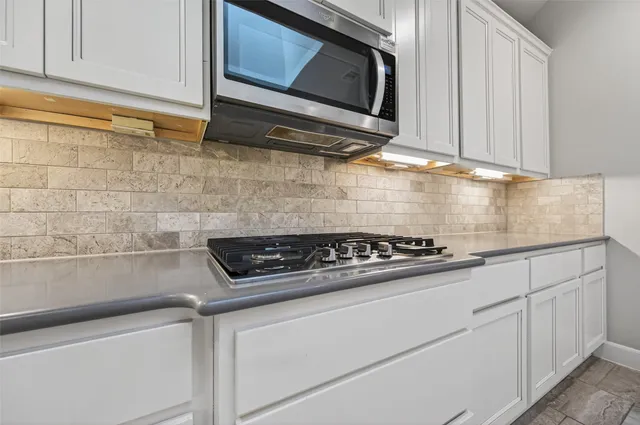 a kitchen with white cabinets and appliances