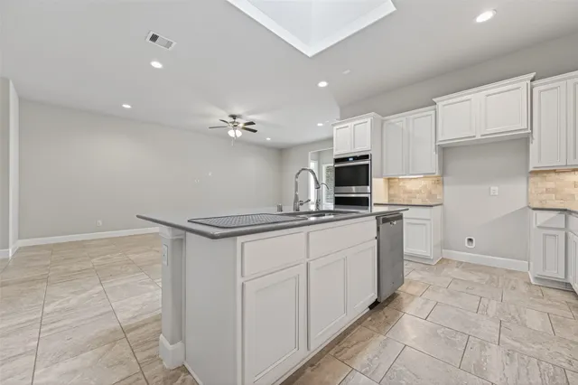 a kitchen with stainless steel appliances a sink stove and cabinets