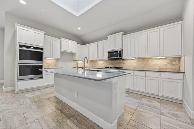 a kitchen with granite countertop a stove sink and cabinets