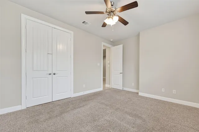 an empty room with chandelier fan