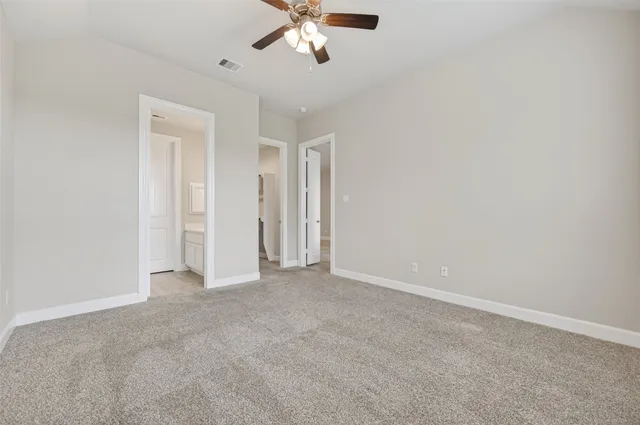 an empty room with chandelier fan