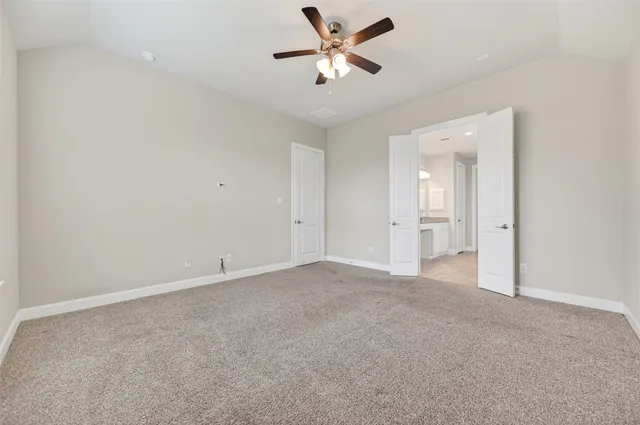 an empty room with closet and a ceiling fan