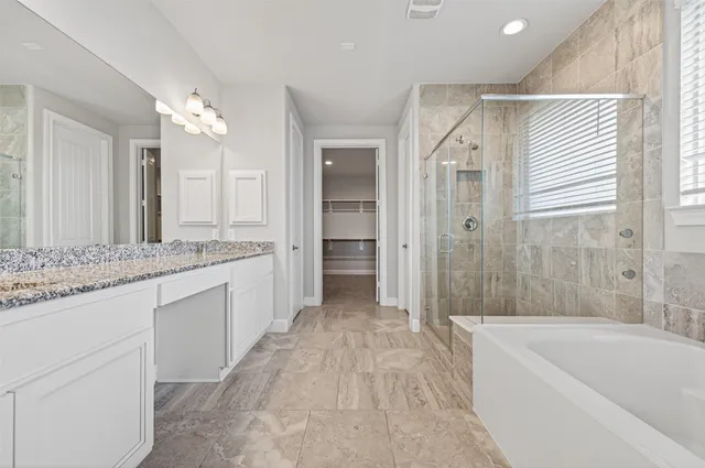 a bathroom with a granite countertop sink a toilet a mirror and bathtub