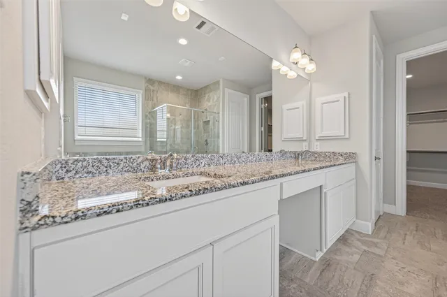 a bathroom with a sink double vanity granite and a mirror