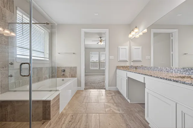 a bathroom with a granite countertop sink a toilet a mirror and bathtub