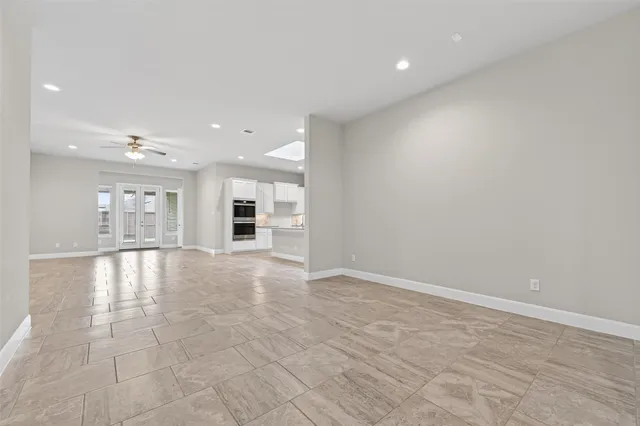 a view of a hallway with wooden floor and a kitchen
