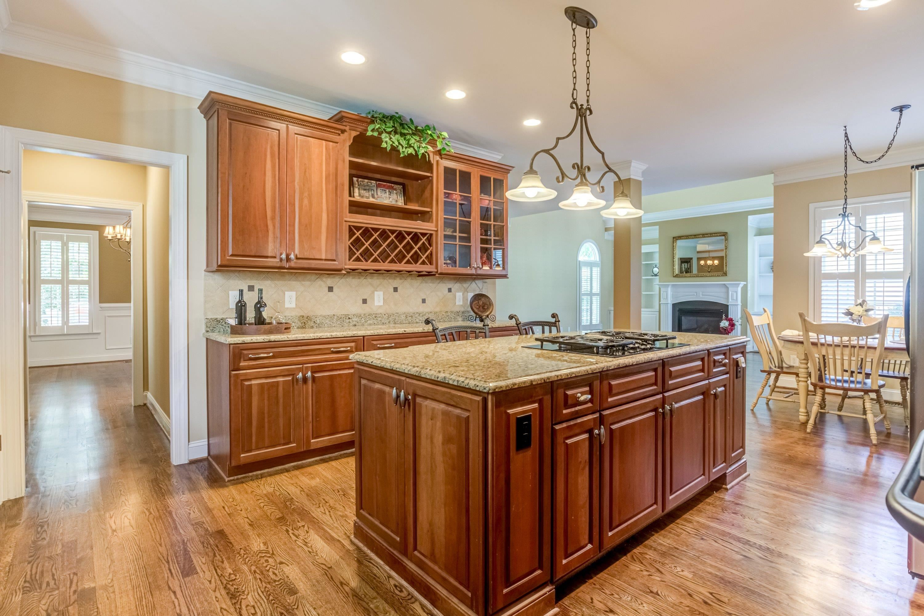 1911 Hornbeck Court Raleigh, NC 27614 - Photo 14 of 47 a kitchen with kitchen island granite countertop a stove a sink a refrigerator and wooden floor