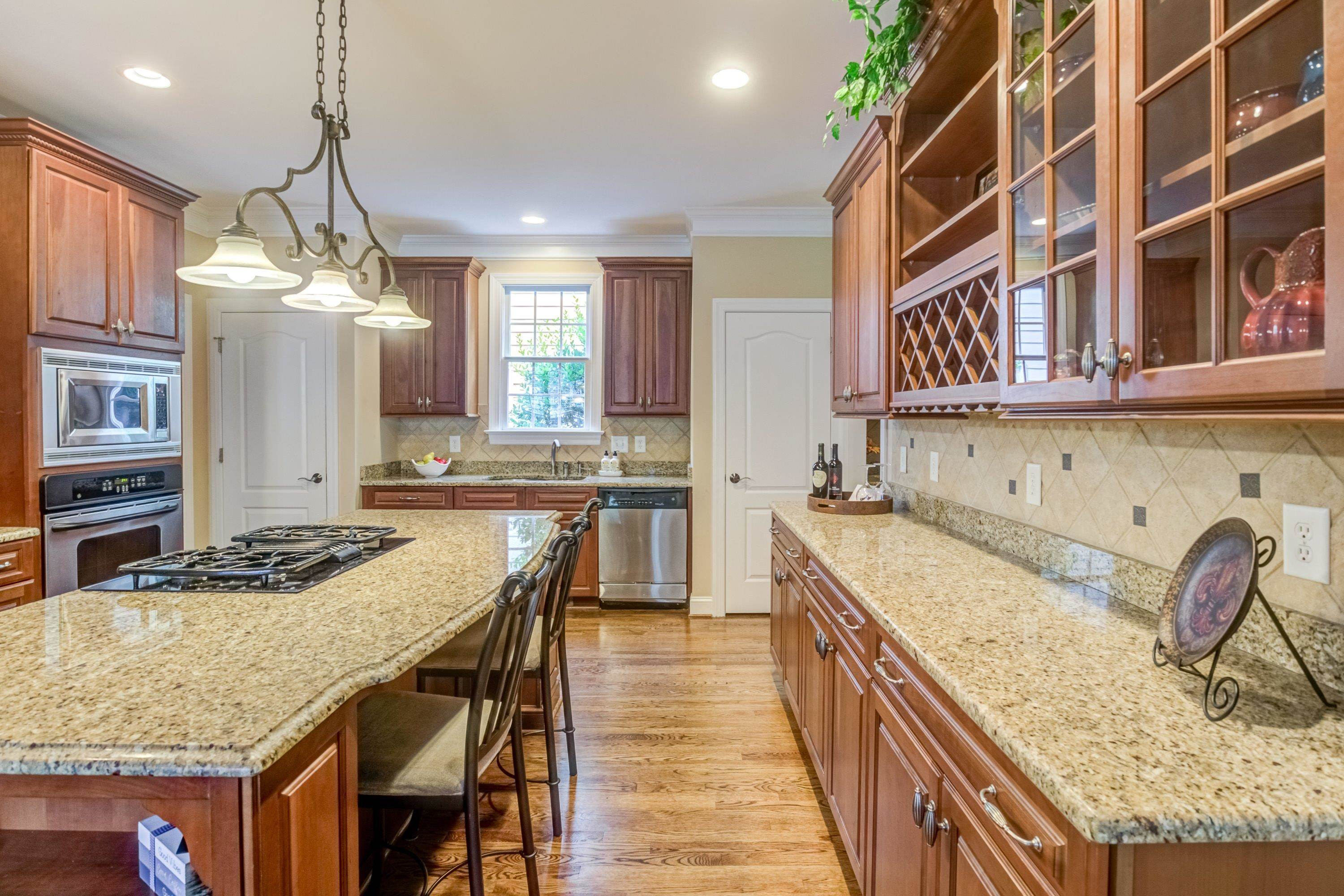 1911 Hornbeck Court Raleigh, NC 27614 - Photo 15 of 47 a kitchen with kitchen island granite countertop wooden cabinets a counter top space and stainless steel appliances