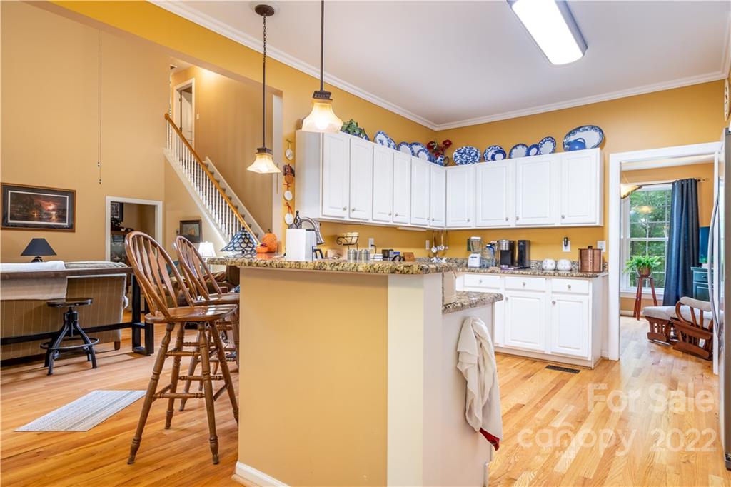 7545 Windy Pine Circle, Unit 30 Denver, NC 28037 - Photo 12 of 38 a kitchen with stainless steel appliances granite countertop a refrigerator a stove and white cabinets with wooden floor
