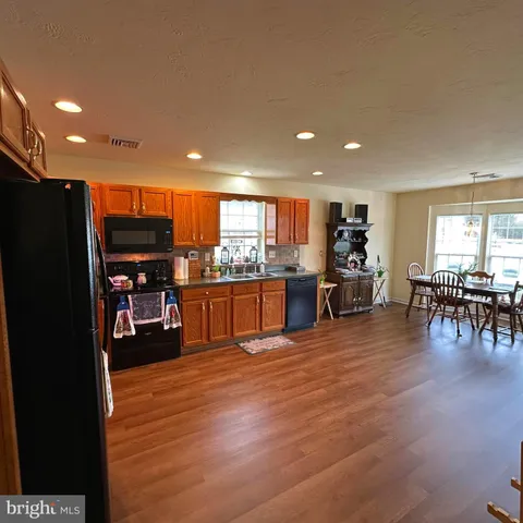 a kitchen with stainless steel appliances granite countertop a refrigerator and a stove top oven