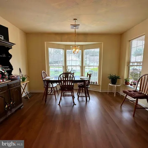 a view of a a dining room with furniture window and wooden floor