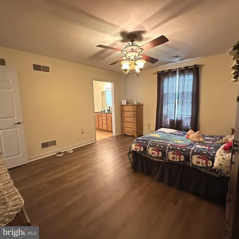 a bedroom with a bed and a flat tv screen on dresser