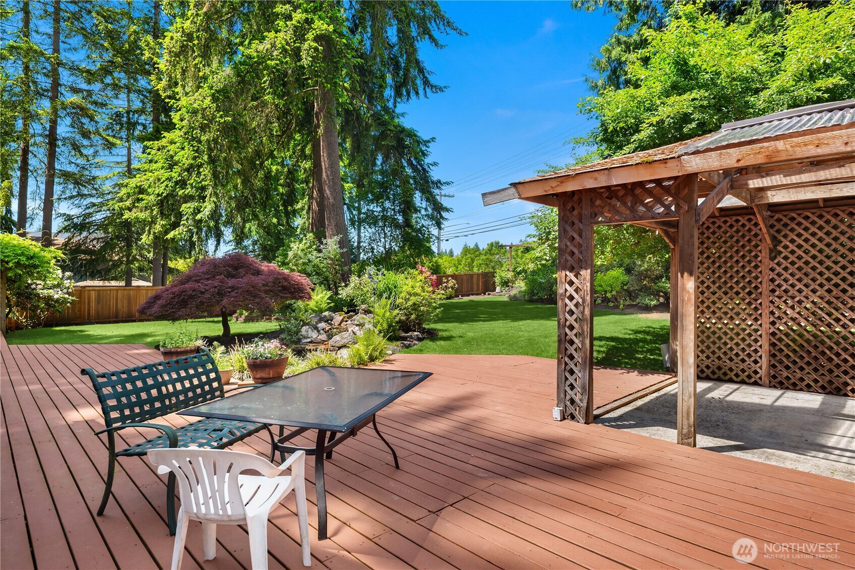 22809 38th Avenue Southeast Bothell, WA 98021 - Photo 29 of 40 a view of a patio with a table and chairs under an umbrella with wooden fence