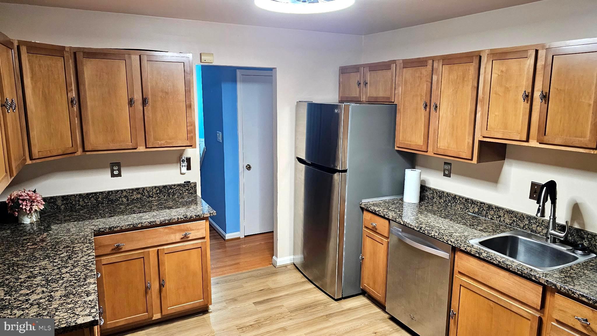 11603 Butlers Branch Road Clinton, MD 20735 - Photo 5 of 42 a kitchen with granite countertop wooden cabinets a sink a stove a refrigerator and island