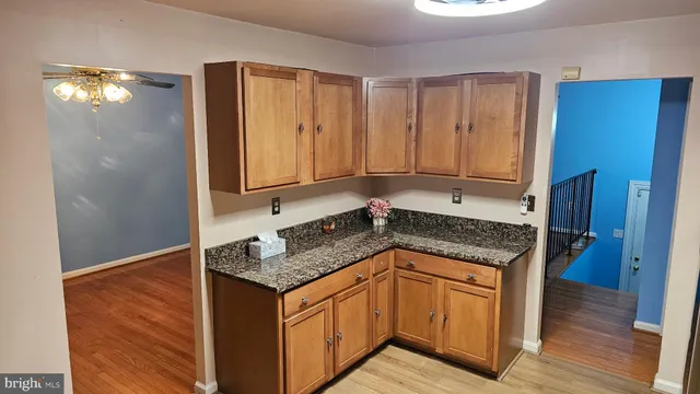 a kitchen with granite countertop cabinets and wooden floor