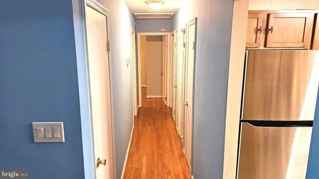 a view of a hallway with wooden floor and door