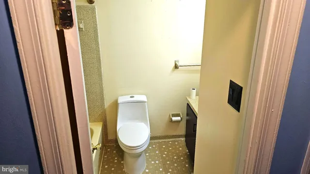 a bathroom with a granite countertop toilet and a sink
