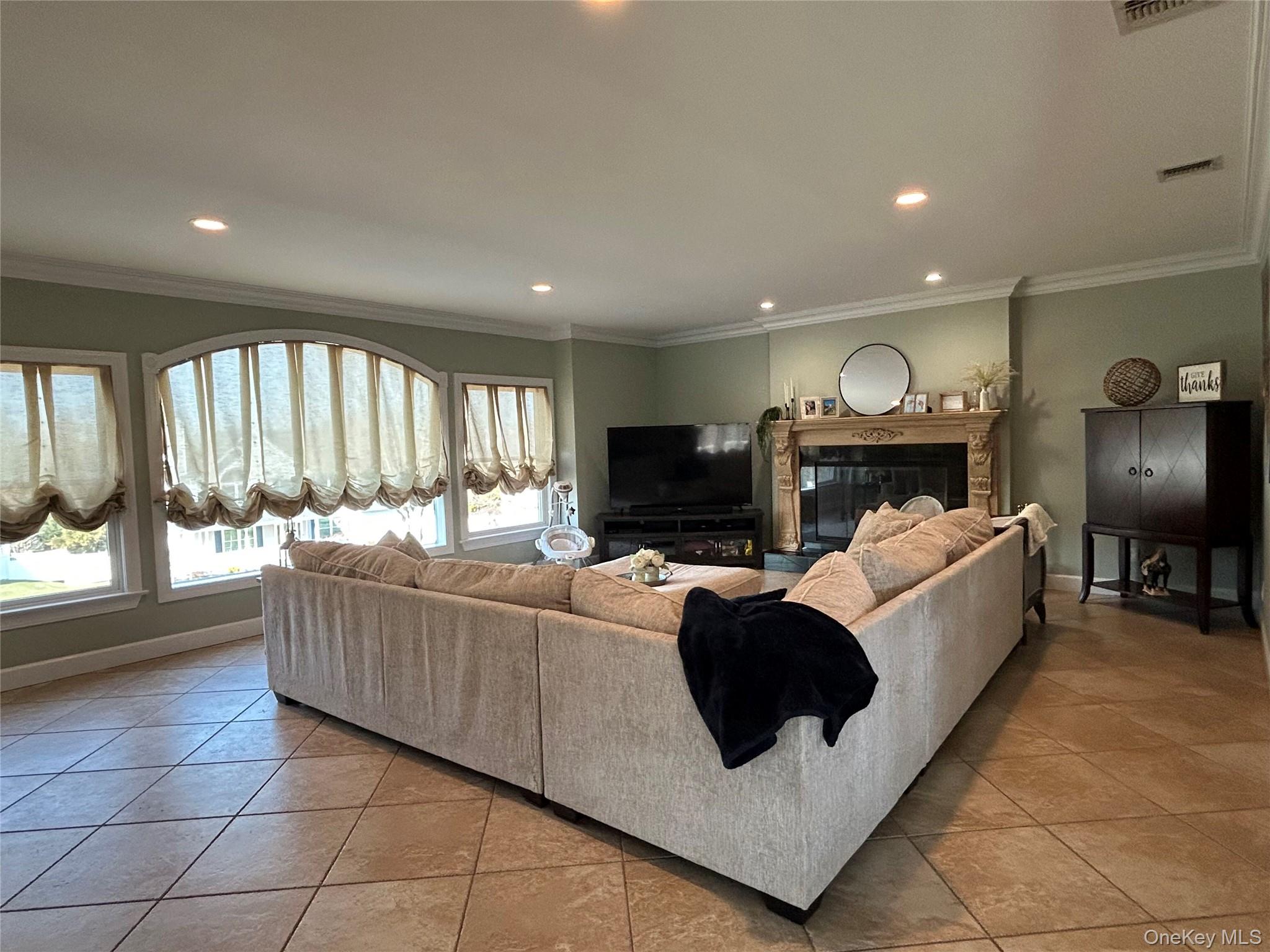 a living room with furniture a flat screen tv and a fireplace