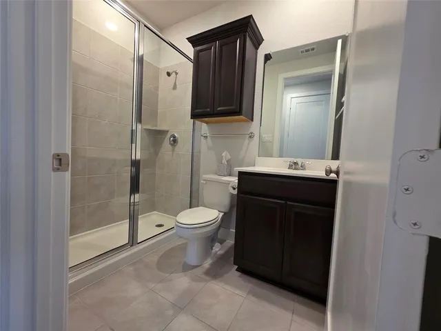 a bathroom with a toilet a sink and glass door
