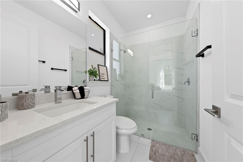 907 Homestead Road South Lehigh Acres, FL 33974 - Photo 15 of 29 a bathroom with a granite countertop sink a toilet and shower