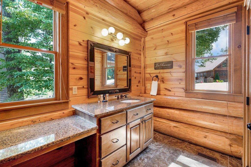 502 Overlook Drive Blue Ridge, GA 30513 - Photo 30 of 53 a bathroom with a granite countertop sink and a large mirror