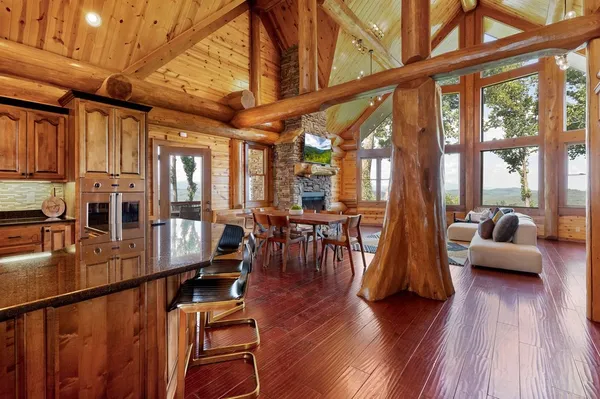 a living room with furniture a wooden floor and a large window
