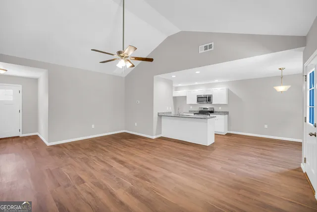 a view of kitchen with granite countertop cabinets and refrigerator