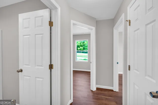 a view of a hallway with wooden floor