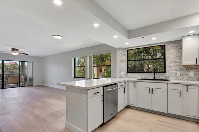 a kitchen with a sink window and cabinets