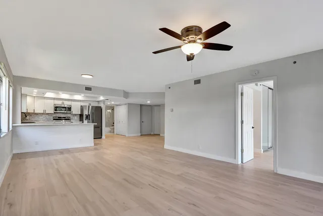 a view of empty room with wooden floor and window