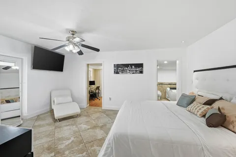 a bedroom with a bed a couch and a flat screen tv