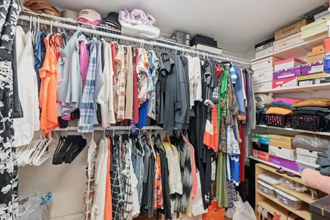 a view of walk in closet with clothes