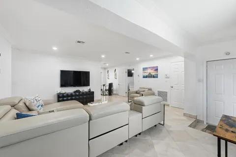 a room with furniture a flat screen tv and a couch