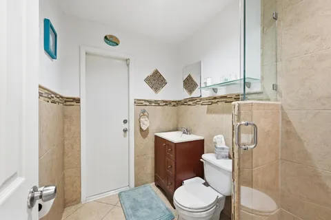 a white toilet sitting next to a bathroom sink and shower