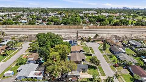 an aerial view of residential building with parking and yard